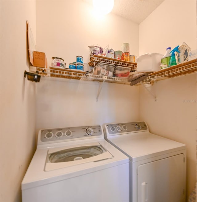 laundry area with laundry area, washer and clothes dryer, and a textured ceiling