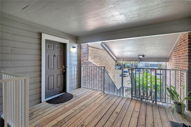 property entrance featuring visible vents, brick siding, and a balcony