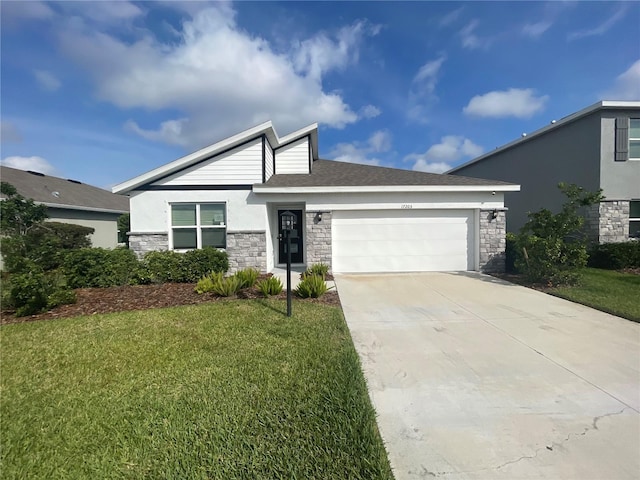 view of front of property with a garage, concrete driveway, stone siding, a front lawn, and stucco siding