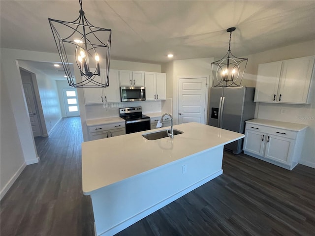 kitchen featuring stainless steel appliances, a sink, white cabinetry, light countertops, and a center island with sink