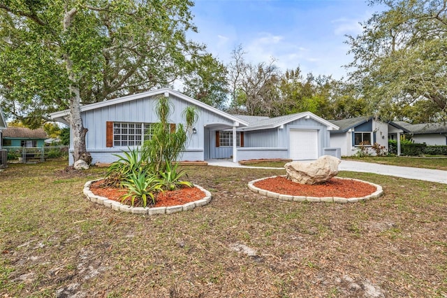 view of front of home featuring concrete driveway, an attached garage, fence, a front lawn, and brick siding