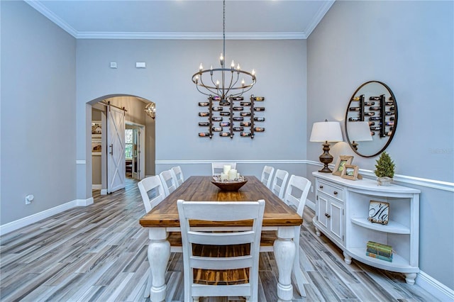 dining room with light wood finished floors, baseboards, arched walkways, and crown molding