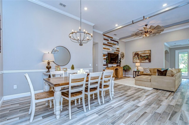 dining space featuring light wood finished floors, ornamental molding, visible vents, and baseboards