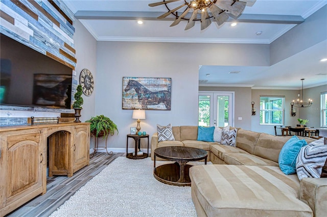 living area with baseboards, wood finished floors, ceiling fan with notable chandelier, crown molding, and recessed lighting