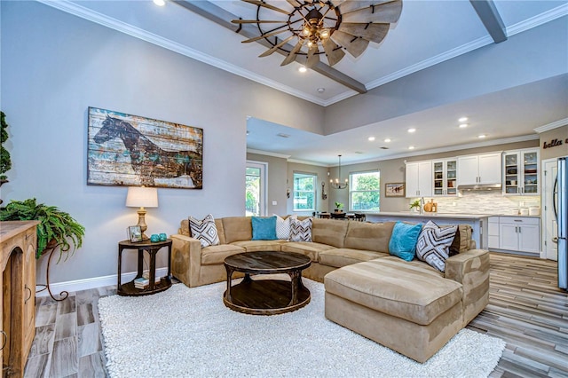 living area featuring ceiling fan, recessed lighting, baseboards, light wood finished floors, and crown molding