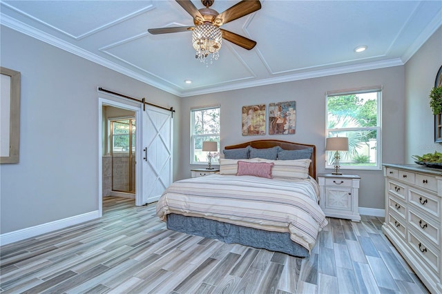 bedroom with a barn door, multiple windows, and light wood-style flooring