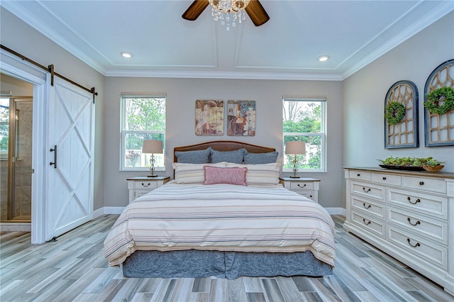 bedroom featuring a barn door, multiple windows, and baseboards