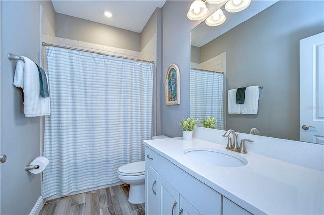 bathroom featuring a shower with shower curtain, vanity, toilet, and wood finished floors