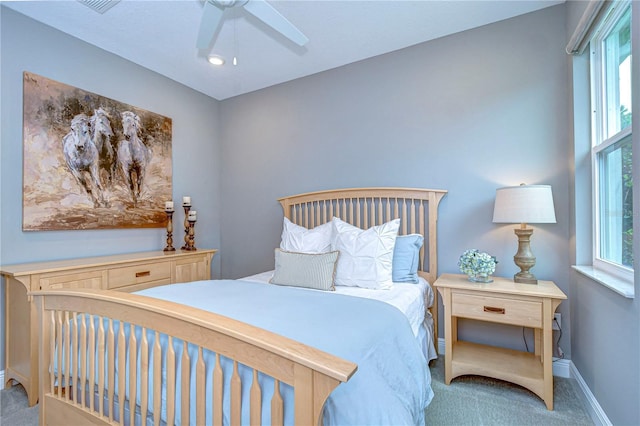 carpeted bedroom featuring baseboards and a ceiling fan