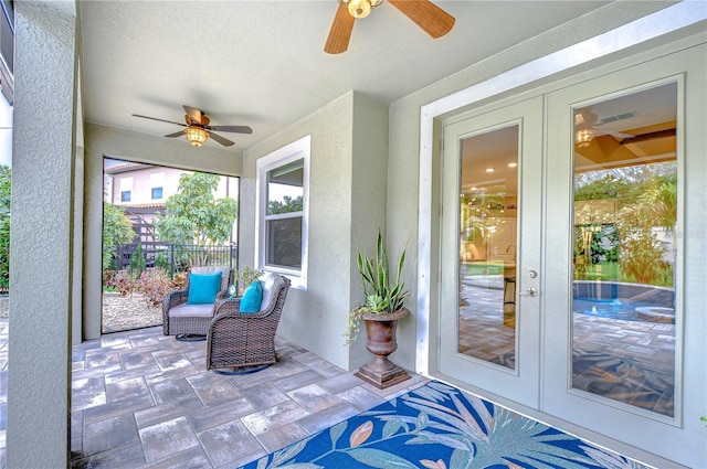 sunroom / solarium with ceiling fan and french doors