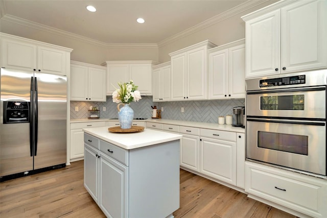 kitchen featuring light wood-type flooring, a kitchen island, ornamental molding, and stainless steel appliances