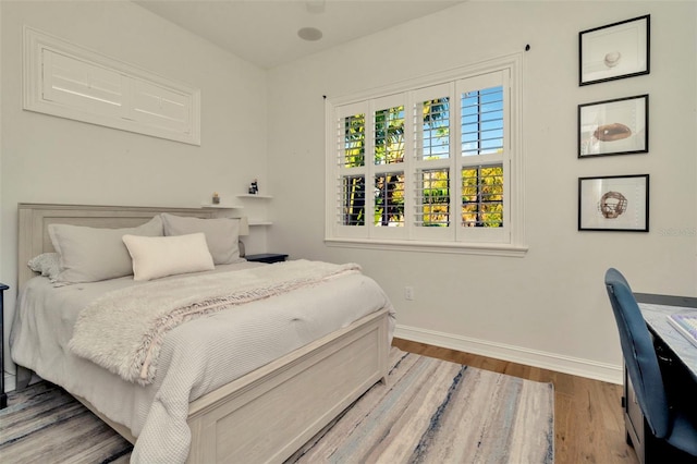 bedroom featuring wood finished floors and baseboards