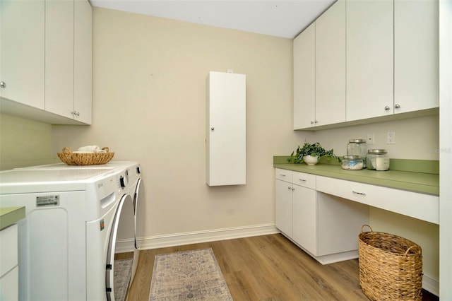 laundry area with cabinet space, light wood-style flooring, baseboards, and separate washer and dryer