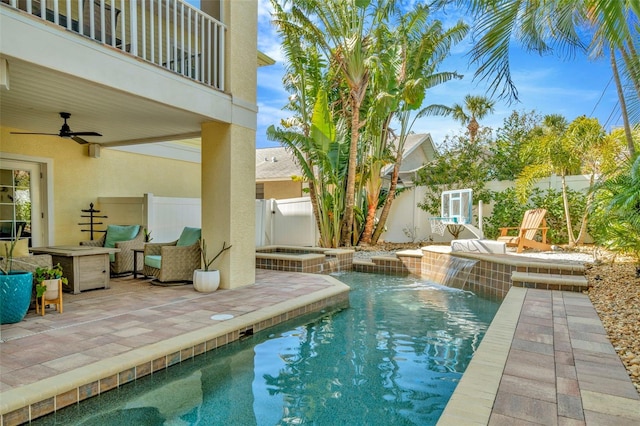 view of swimming pool featuring a ceiling fan, a pool with connected hot tub, a fenced backyard, and a patio