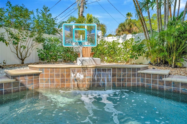 view of basketball court with a fenced backyard