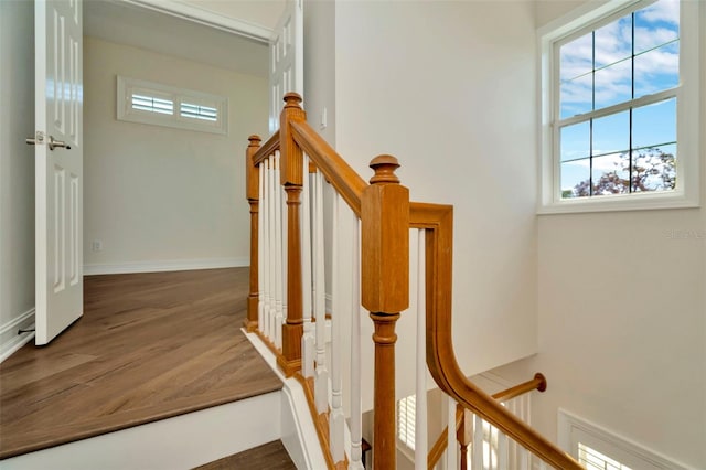 stairway featuring wood finished floors and baseboards