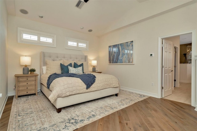 bedroom with visible vents, baseboards, and wood finished floors