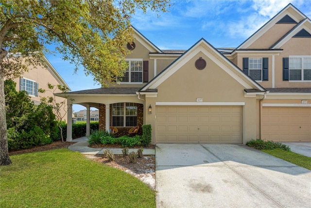 view of front of house with a front yard, driveway, and stucco siding