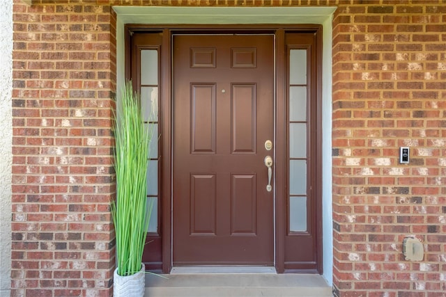 view of exterior entry with brick siding