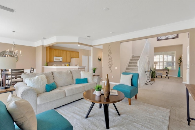 living room featuring a chandelier, stairway, visible vents, and ornamental molding