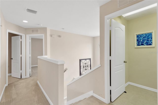 corridor with visible vents, an upstairs landing, and baseboards