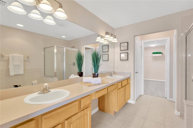 bathroom with a sink, a stall shower, double vanity, and tile patterned flooring