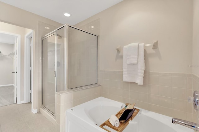 full bath with a garden tub, recessed lighting, a stall shower, a walk in closet, and tile patterned floors