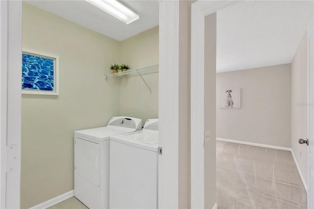 clothes washing area featuring light carpet, laundry area, baseboards, and separate washer and dryer