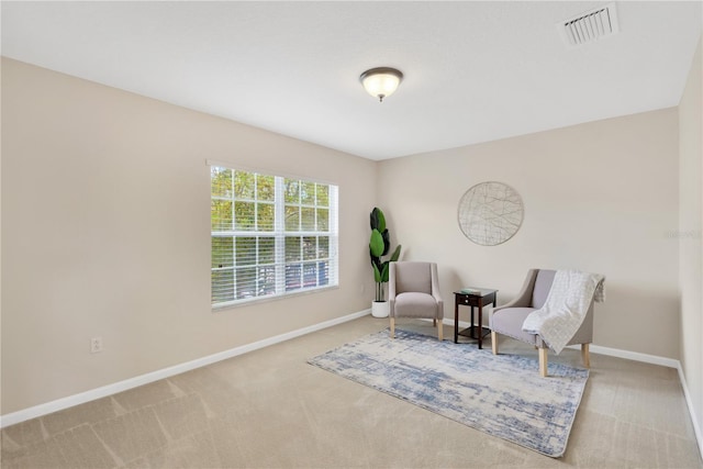 living area featuring visible vents, baseboards, and carpet