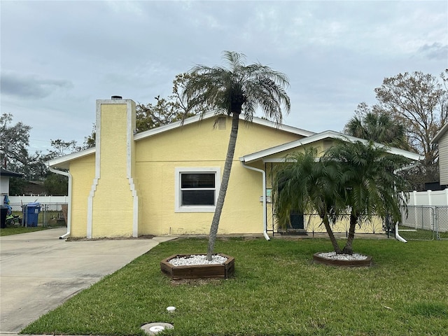 exterior space featuring fence, a chimney, a front lawn, and stucco siding