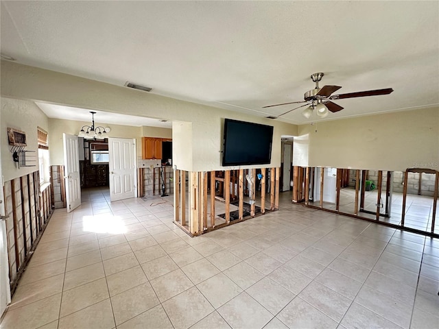 empty room with ceiling fan with notable chandelier and light tile patterned floors