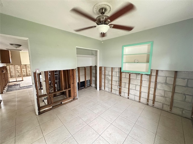 empty room with light tile patterned floors and ceiling fan