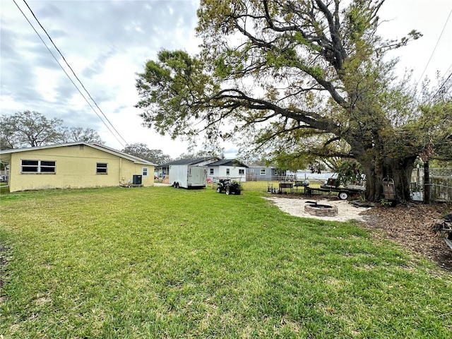 view of yard with a fire pit and fence