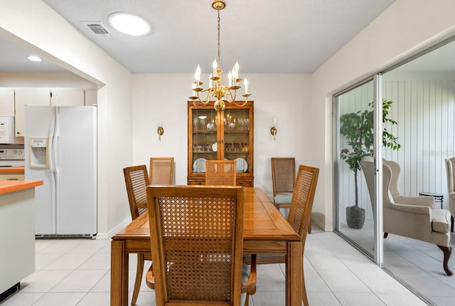 dining area with light tile patterned floors, baseboards, visible vents, and a chandelier