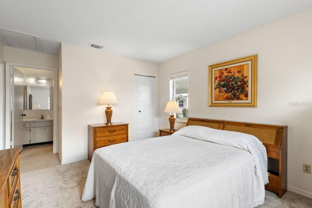 bedroom with baseboards, visible vents, a closet, and light colored carpet