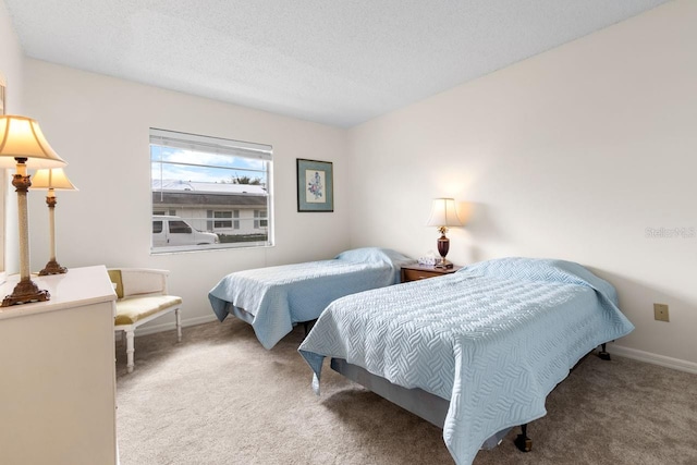 bedroom with a textured ceiling, carpet floors, and baseboards