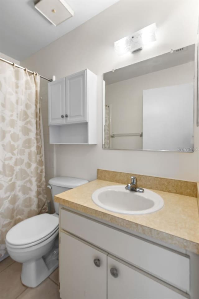 bathroom featuring tile patterned flooring, vanity, and toilet