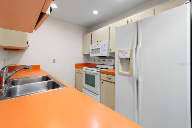 kitchen with white appliances, light countertops, a sink, and cream cabinets