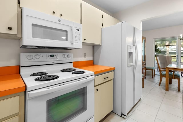 kitchen featuring light tile patterned floors, light countertops, white appliances, and white cabinets