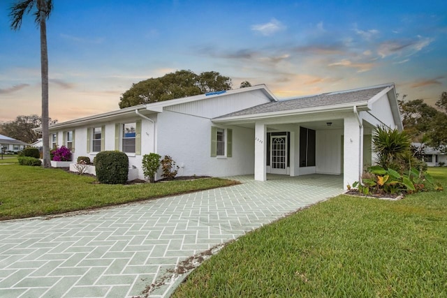 ranch-style home featuring a front yard and stucco siding