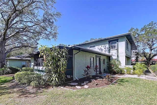 exterior space with a lawn and stucco siding