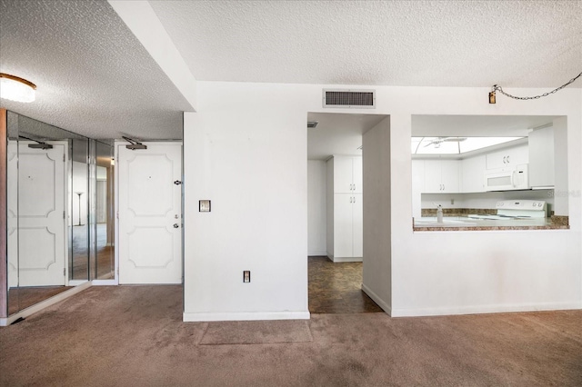 unfurnished room with baseboards, visible vents, a textured ceiling, and carpet flooring