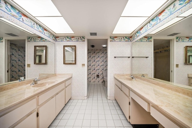 bathroom featuring a shower, a skylight, toilet, a sink, and wallpapered walls