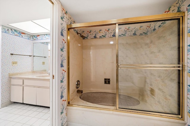 bathroom featuring wallpapered walls, a skylight, tile patterned floors, combined bath / shower with glass door, and vanity