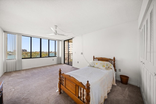 carpeted bedroom featuring a textured ceiling, a ceiling fan, baseboards, access to outside, and a closet