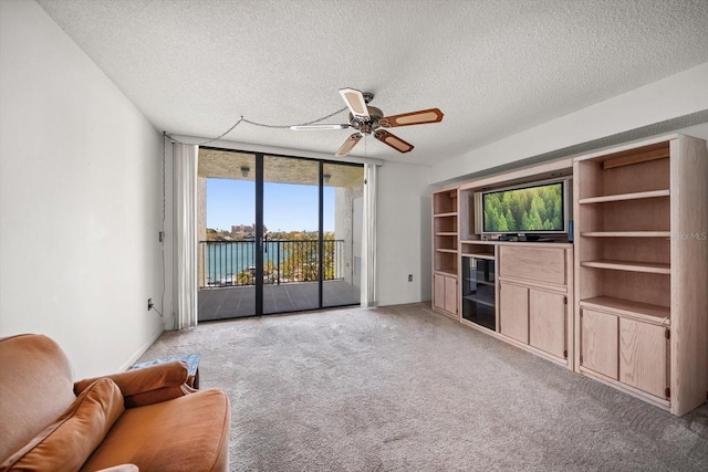 unfurnished living room with floor to ceiling windows, light carpet, plenty of natural light, and a textured ceiling