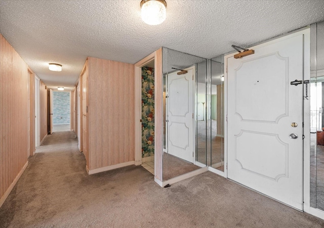 interior space with wood walls, carpet, and a textured ceiling