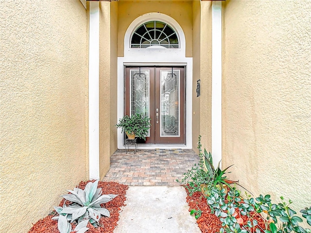 doorway to property featuring stucco siding