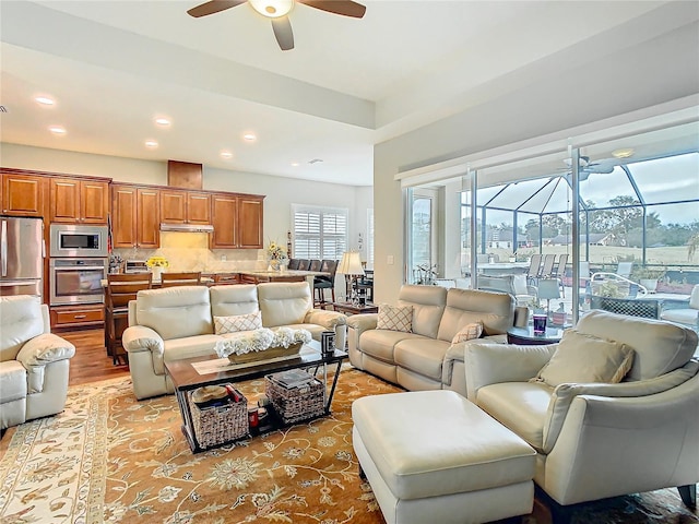 living area with light wood finished floors, recessed lighting, a sunroom, and a ceiling fan