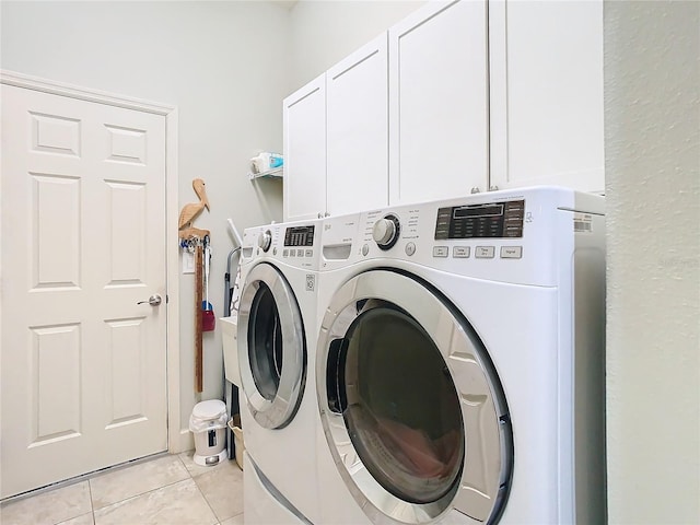 laundry area featuring cabinet space, washer and clothes dryer, and light tile patterned floors